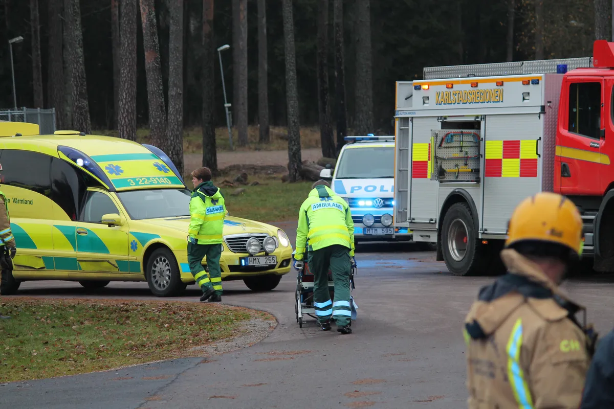 Ambulance, police car and fire truck at accident scene in forest setting