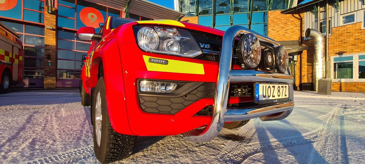 Red command vehicle with bull bar in front of Karlstad fire station in winter